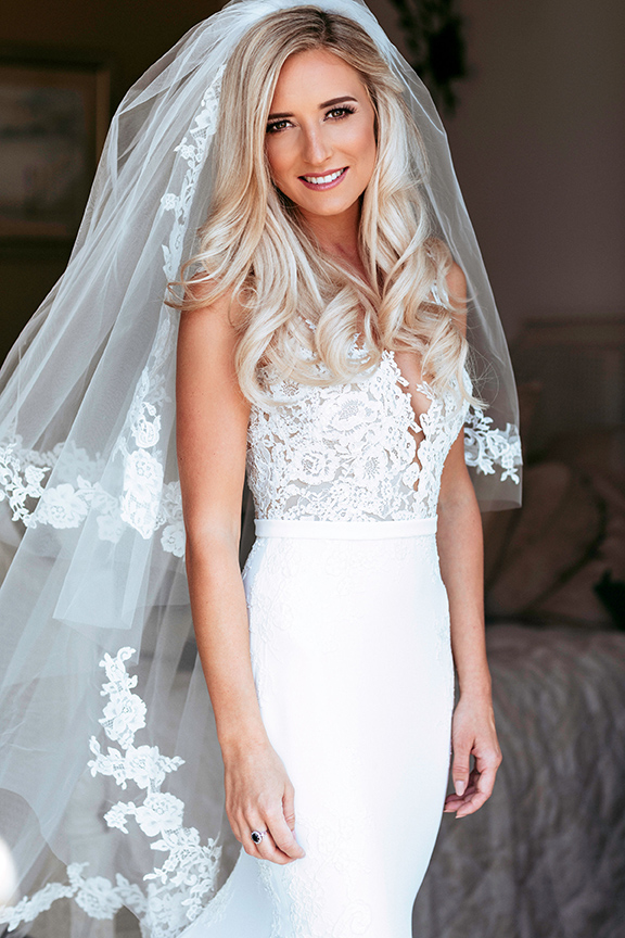A bride in a lace gown and cathedral veil