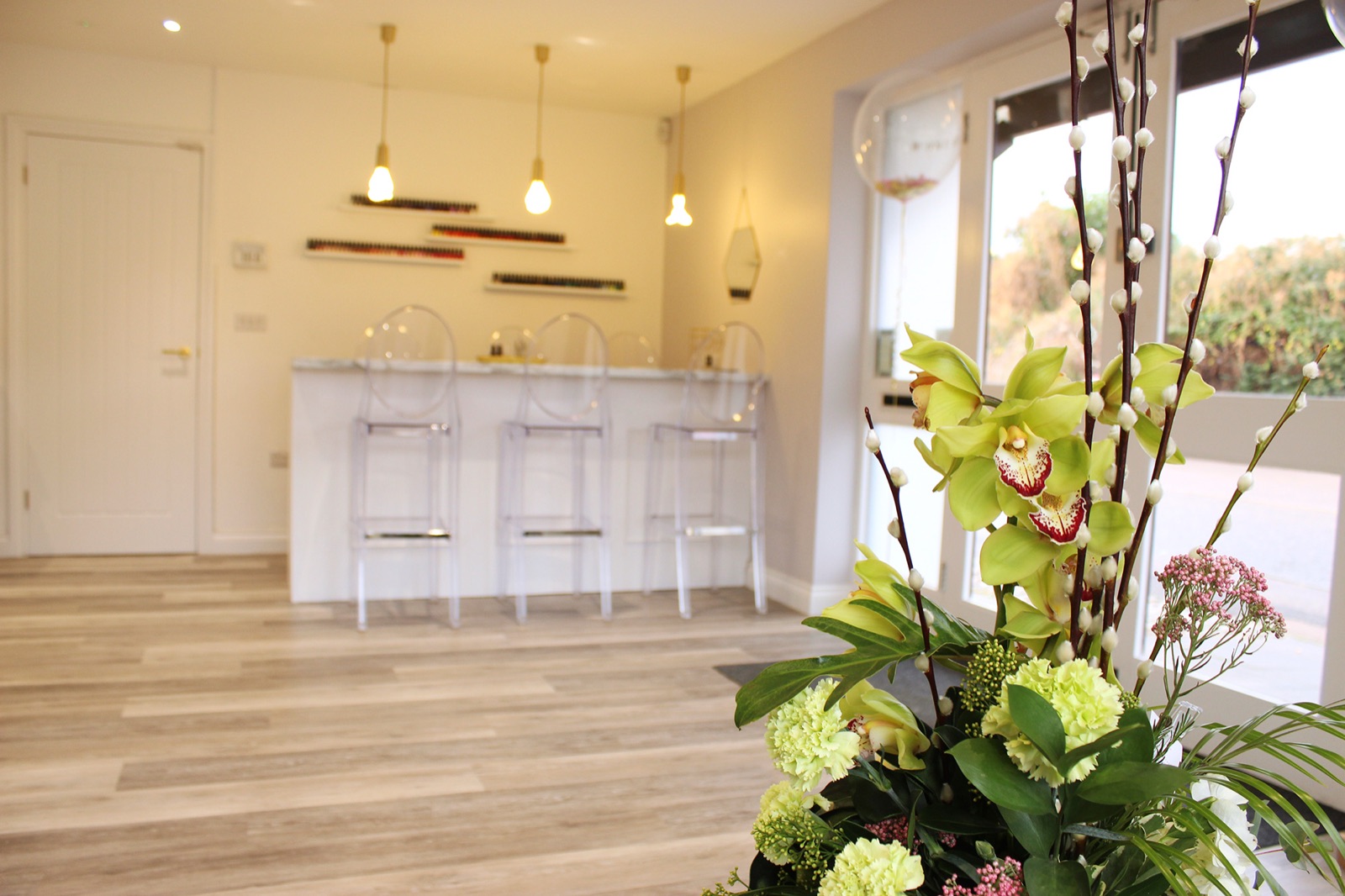 The reception desk with pendant lights and orchids